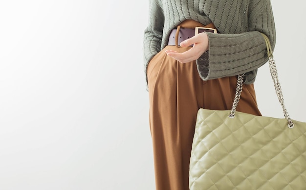 Foto menina de roupas modernas com bolsa de mão em fundo branco