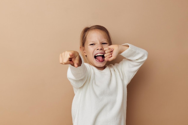 Menina de suéter branco posando gestos de mão infância inalterada