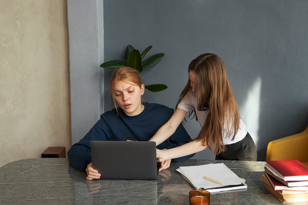 Foto menina de tiro médio incomodando mulher no trabalho