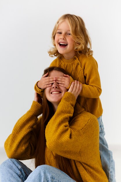 Foto menina de tiro médio, mãe surpreendente