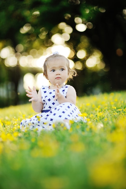 Menina de vestido branco sentado na grama