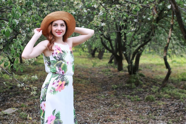 Menina de vestido e chapéu de palha no parque