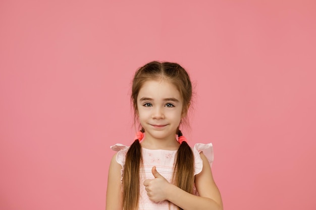 Menina de vestido mostrando os polegares para cima