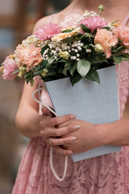 Menina de vestido rosa segurando um buquê de flores