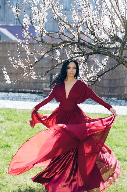 Menina de vestido vermelho perto da flor