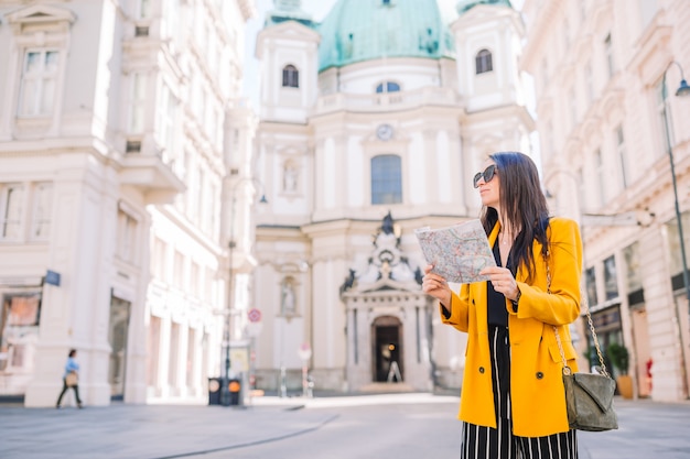 Menina de viagens com um mapa em Viena ao ar livre durante as férias na Europa.