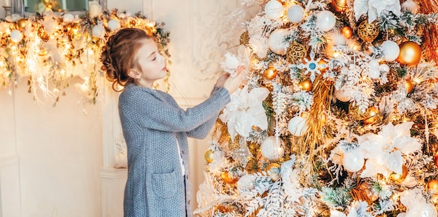 Menina decorando árvore de natal