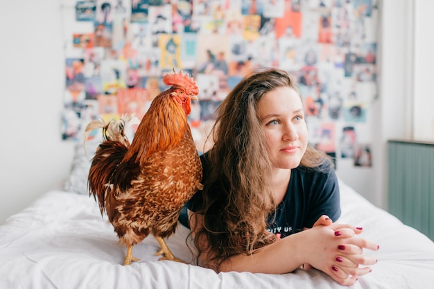 Menina deitada na cama com um galo