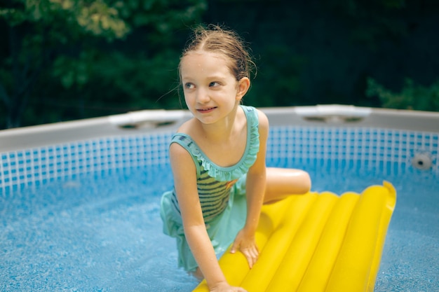 Menina deitada no flutuador da piscina