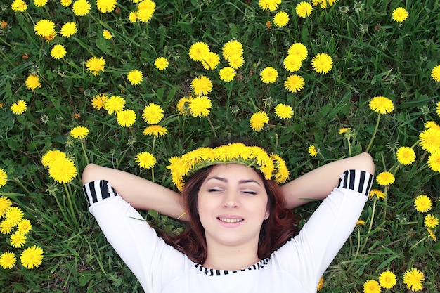 Menina descansando em um dia ensolarado em um prado de flores amarelas