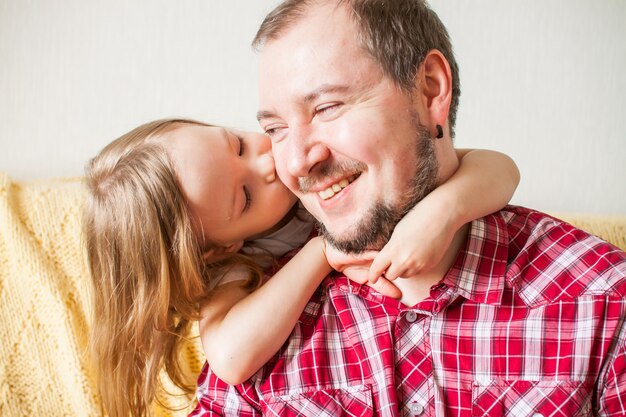 Menina deseja pai feliz dia dos pais. Filha abraça o pai.