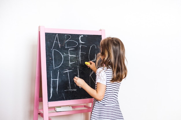 Menina desenha quadro de giz