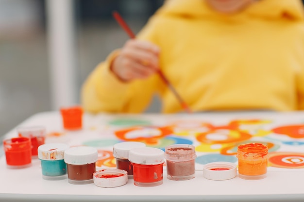 Menina desenhando imagens de arte pintando com pincel e guache