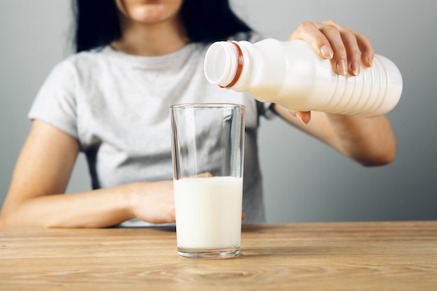 Menina despeja leite em um copo