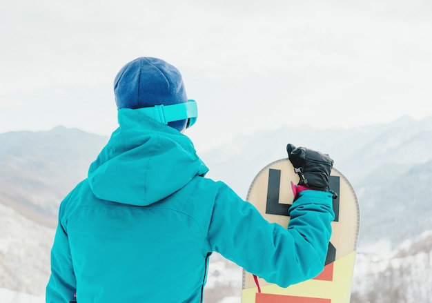 Foto menina desportiva com snowboard ao ar livre