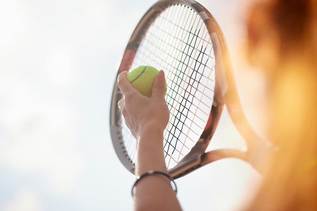 Menina desportiva preparando-se para servir uma bola de tênis Vista de perto de uma menina bonita segurando uma bola de ténis e uma raquete