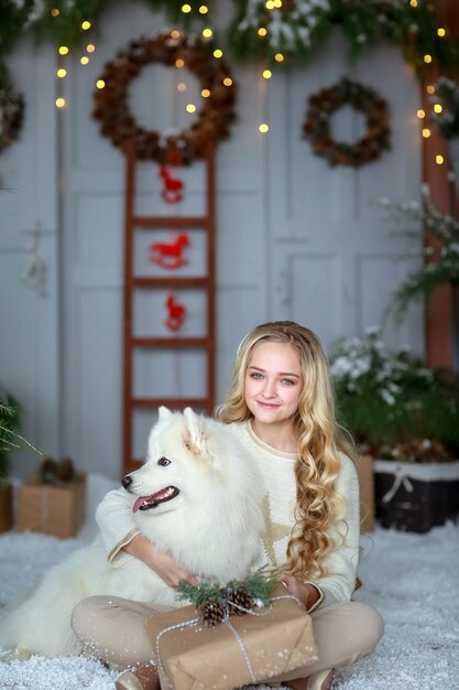 Menina do conceito de ano novo com seu animal de estimação posando em um estúdio fotográfico