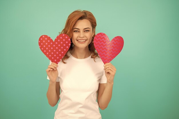 Menina do conceito de caridade com coração vermelho sobre fundo azul