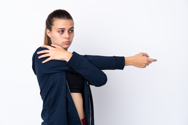 Foto menina do esporte adolescente sobre branco isolado, esticando o braço