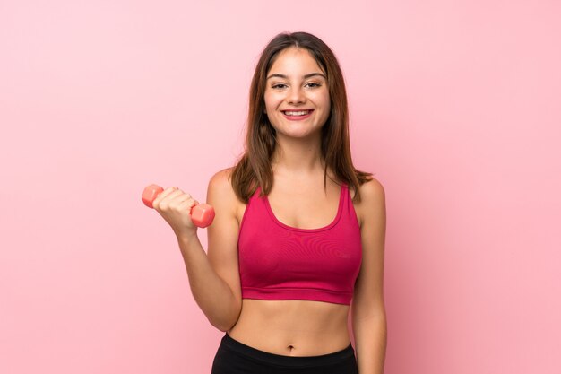 Menina do esporte jovem isolado rosa fazendo levantamento de peso
