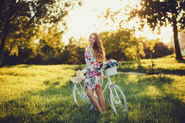 Menina do vintage ao lado de bicicleta