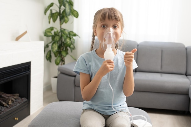 menina doente faz inalação sobre fundo cinza com espaço de cópia. Garota fazendo inalação com nebulizador em casa. criança asma inalador inalação nebulizador vapor doente tosse.