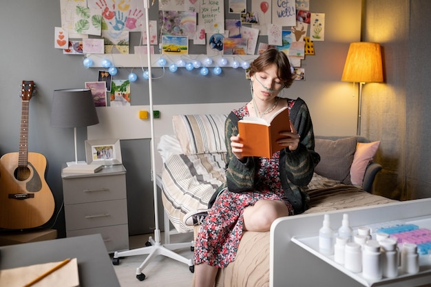 Foto menina doente lendo um livro na enfermaria do hospital