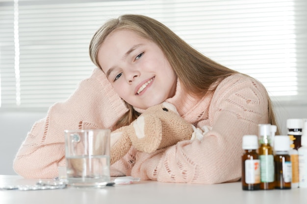 Menina doente tomando remédio em casa