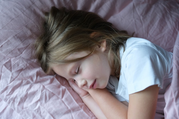 Menina dormindo na cama rosa em casa