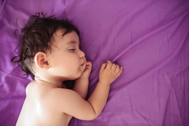 Menina dormindo no lençol roxo