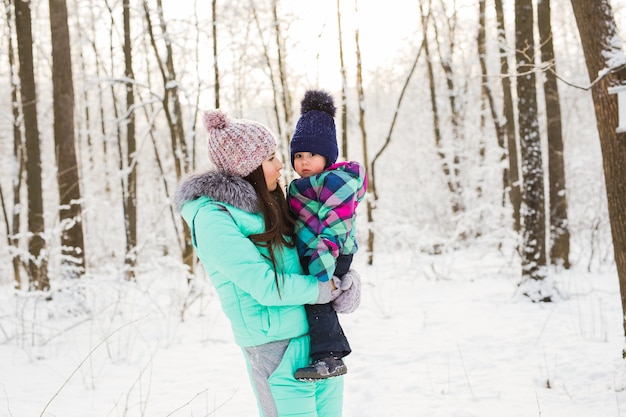 Menina e a mãe dela se divertindo em um dia de inverno.