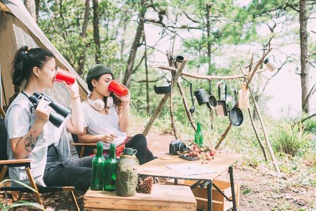 Menina e amigos acampando na floresta