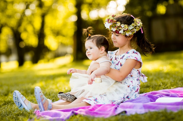 Menina e bebê sentado na grama