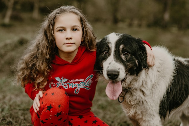 Menina e cachorro como amigos felizes juntos no outono na natureza