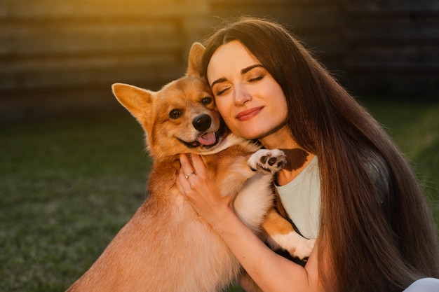 Foto menina e cachorro corgi em casa retrato aproximado jovem sorri e abraça welsh corgi pembroke lifestyle com animal doméstico