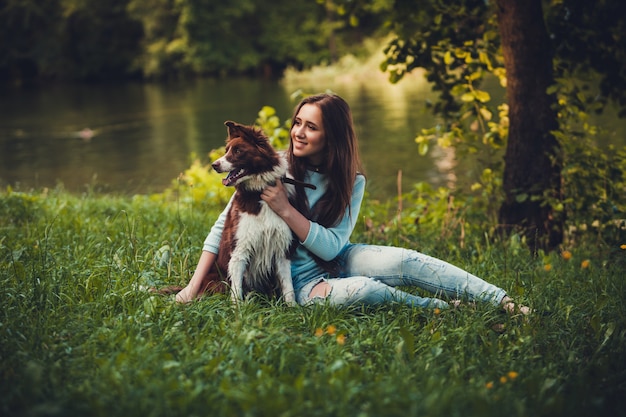 Menina e cachorro sentado na grama