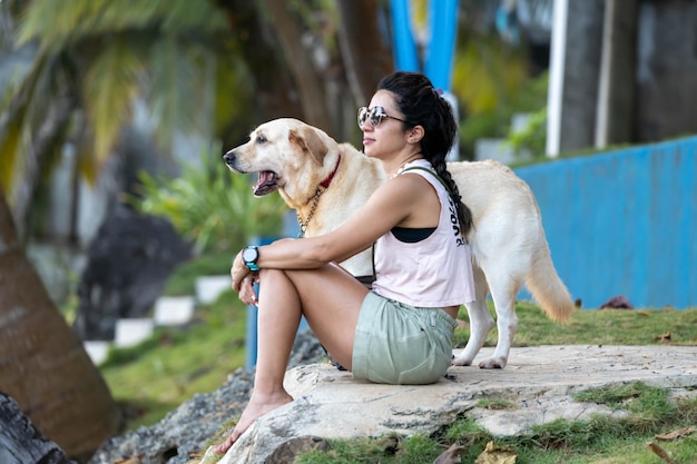 Menina e cachorro sentados no chão