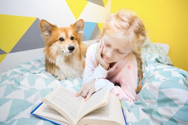 Menina e cão na cama no berçário