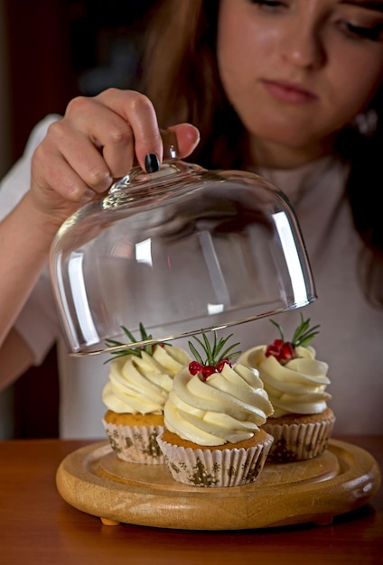 Menina e cupcakes Mulher bonita com bolos doces em fundo escuro