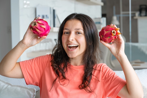 Menina e fruta do dragão. menina alegre, desfrutando de frutas tropicais.