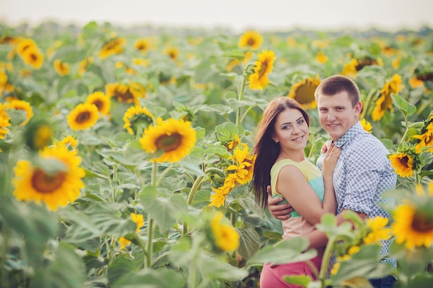 Menina e homem em um campo de girassóis