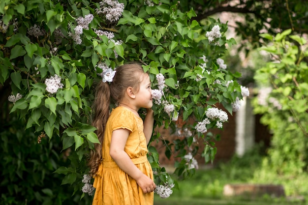 menina e lilás flores no jardim no verão