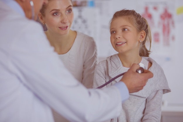 Menina e médico com estetoscópio ouvindo batimentos cardíacos