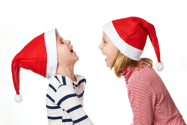 Menina e menino com chapéu de Papai Noel