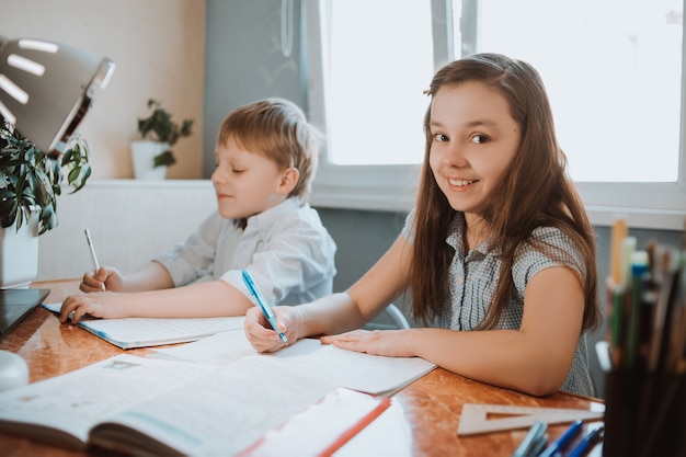 Menina e menino escrevendo sua lição de casa