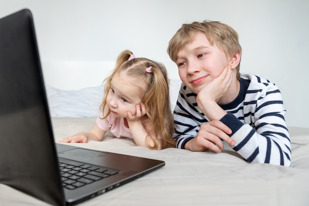 Menina e menino usando o laptop em casa