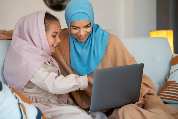 Menina e mulher de tiro médio com laptop