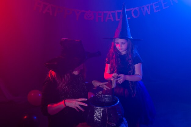 Menina e mulher engraçadas com fantasias de bruxas para o dia das bruxas com jack de abóbora