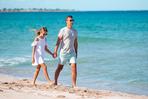 Menina e pai feliz se divertindo durante as férias na praia