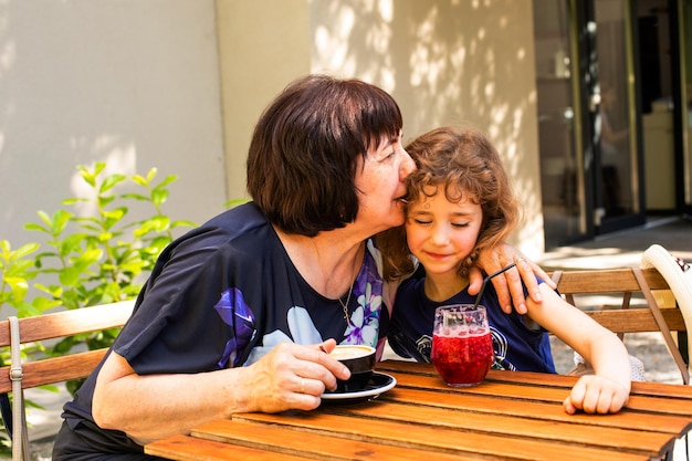 Menina e sua avó bebem café e coquetel